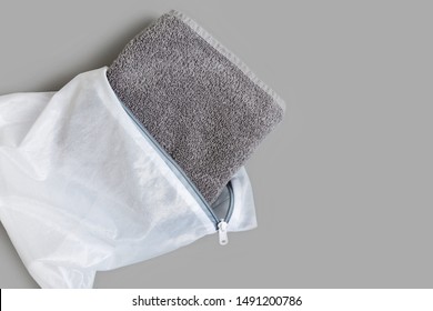 Gray Towel Folded In White Mesh Laundry Bag To Protect Delicate Fabric In Wash. Isolated On Gray Background