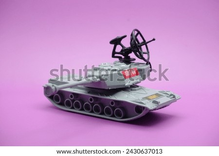 gray toy tank isolated on purple background. imitation of a tank commonly used by the armed forces.