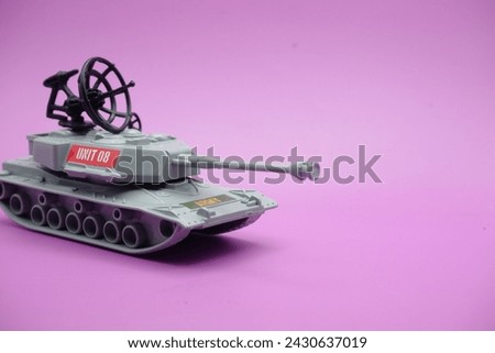gray toy tank isolated on purple background. imitation of a tank commonly used by the armed forces.