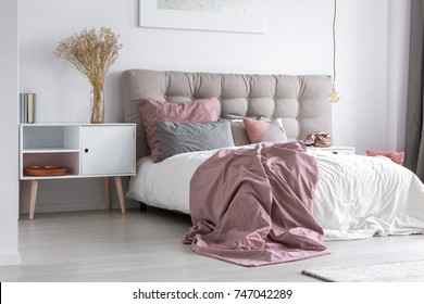 Gray Tufted Headboard And Pink Bedcover In Simple Bedroom With Minimalist Interior Design And Copper Accessories
