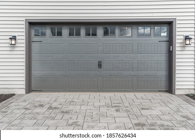 Gray Two Single Car Garage Door Framed With Architectural Stone To Add Accent, With Transom Light Windows Divided By Muntins Grills 