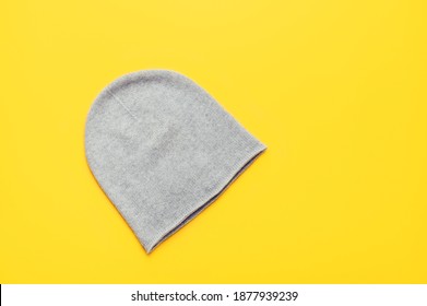 Gray unisex cashmere beanie on yellow background, trendy colors 2021, Top View, Copy Space - Shutterstock ID 1877939239