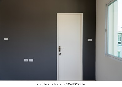 Gray Wall Decoration Of The Bedroom With White Door Closed.