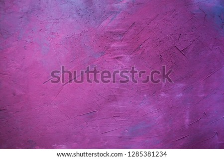 Gray wall painted in pink, mauve and purple. Visible plaster texture. Abstract background