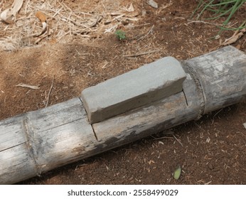 Gray whetstone in bamboo ideal for outdoor, gardening, tool sharpening, zen concepts, product designs, or kitchen utensil themes. - Powered by Shutterstock