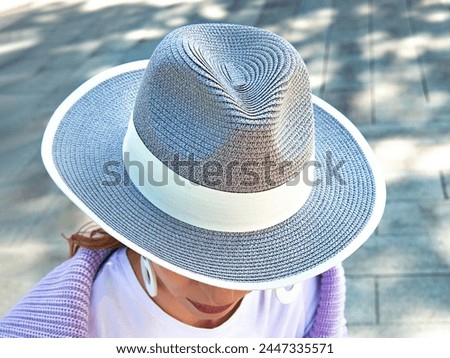 Gray wicker hat with wide brim. Summer hat with wide brim and white stripe.