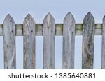 A gray wood pickett fence closeup appears.