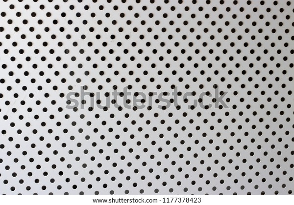 Gray wood surface with pattern of round black\
cutout holes, texture,\
background