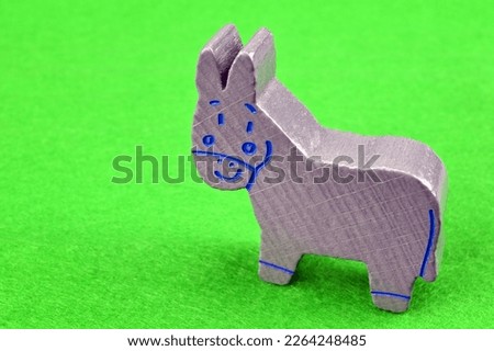 Gray wooden donkey on green background