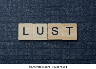 Gray Word Lust From Small Wooden Letters On A Black Table