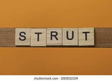 Gray Word Strut Made Of Wooden Square Letters On Brown Background