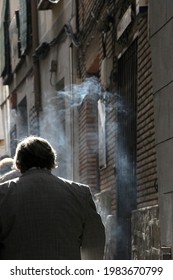 Gray-haired Man Walking Backwards And Smoking