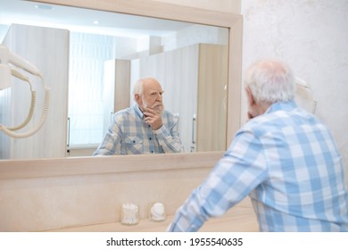 Gray-haired Mature Man Looking In The Mirror In A Changing Room In Spa Center