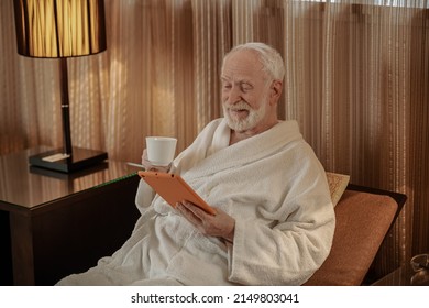 Gray-haired senior man having morning coffee and looking thoughtful - Powered by Shutterstock