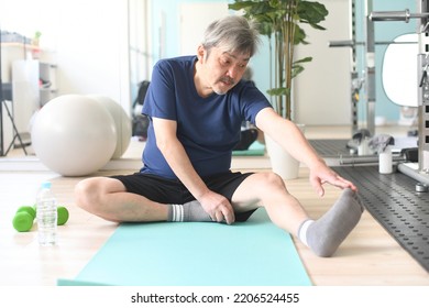 Gray-haired Senior Man Stretching Indoors