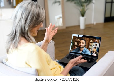 Gray-haired Senior Woman Using Online Platform For Online Communication With Colleagues, Indian Male And Other Participants On The Laptop Screen, Mature Female Talking, Diverse People Listening