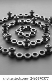 Grayscale Image Of Mechanical Pattern Part Made With Same Metal Nuts And Screwed Cross Head Bolts. Vertical Stock Photo For Mechanism Illustration