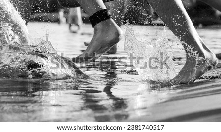 A grayscale of people swimming in open water under the natural light