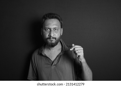 A Grayscale Portrait Of A South Asian Male On A Dark Background