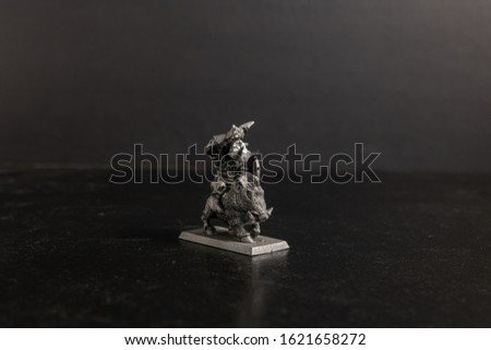 A grayscale selective focus shot of a creature riding a boar figurine