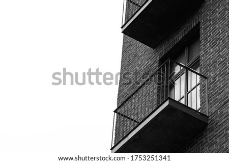 A grayscale shot of a brick building facade on a white sky background