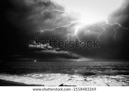 A grayscale shot of dramatic cloudy sky with thunderstorm and lightning