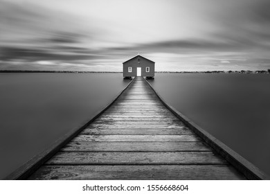 A Grayscale Shot Of A Wooden Road Leading To A Lonely House - Imaginary World Concept