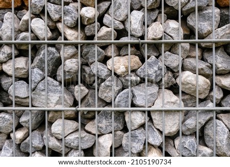 Graystones in the gabion. Fencing decorative. Retaining wall. Close up.