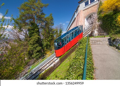 GRAZ, AUSTRIA - APRIL 6, 2010: Bright red funicular (Schlossbergbahn) travels up to Schlossberg hill from the city center during warm spring day. It gives panoramic aerial view of the city downtown - Shutterstock ID 1356249959