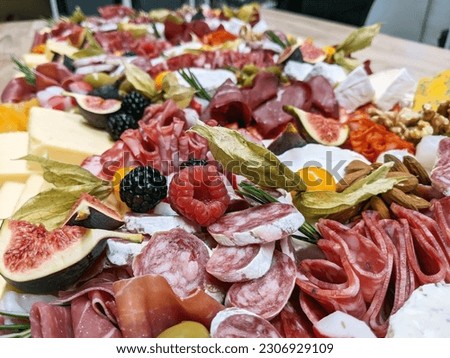 Grazing table containing cured meats, charcuterie, cheese and fruit