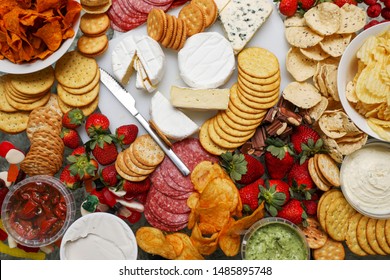 A Grazing Table Filled With Cheese, Crackers, Strawberries, Salami, Chips, Dips And Other Fresh Food For Entertaining. 