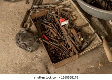 Greasy Tools On Dirty Concrete Floor. Messy Garage