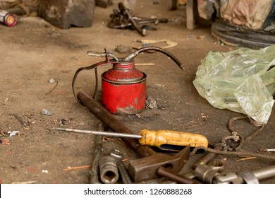 Greasy Tools On Dirty Concrete Floor. Messy Garage