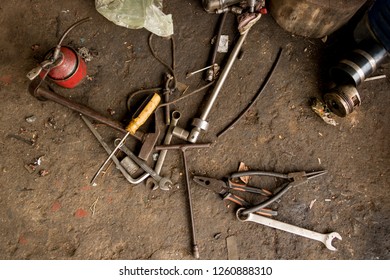 Greasy Tools On Dirty Concrete Floor. Messy Garage