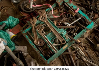 Greasy Tools On Dirty Concrete Floor. Messy Garage