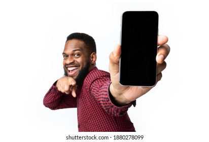 Great App. African Man Showing Phone Blank Screen Recommending New Mobile Application Posing Over White Studio Background, Smiling To Camera. Apps Advertisement With Smartphone Display Mockup