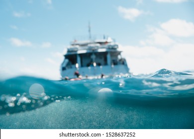 Great barrier reef, Australia: Cruise boat in the middle of the ocean, underwater photo, half/half, blur
