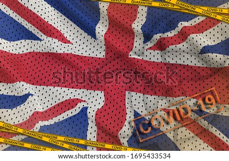 Great britain flag and Covid-19 biohazard symbol with quarantine orange tape and stamp. Coronavirus or 2019-nCov virus concept