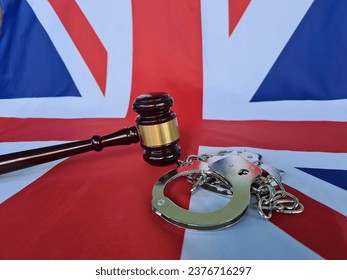Great Britain flag with judge gavel and handcuffs. Criminal offense and punishment, background of guilty topics