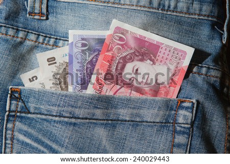 Great Britain pound banknotes in back pocket of blue jeans
