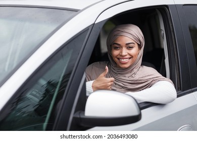 Great Car, Successful Test Drive And Driving School, Buying New Auto In Dealership. Smiling Millennial Pretty Cute Arab Afro American Lady Driver In Hijab Showing Thumb Up In Car On Steering Wheel