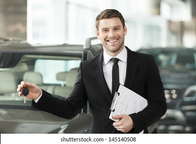 Great Choise! Handsome Young Classic Car Salesman Standing At The Dealership Holding A Key