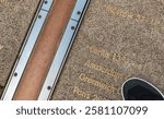 Great close-up view of the Greenwich Prime Meridian marked by the brass strip on the ground with several well known capital cities.