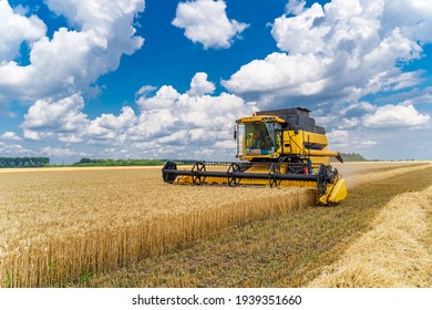 Great combine harvester working at the field. Agricultural machine on the blue sky.