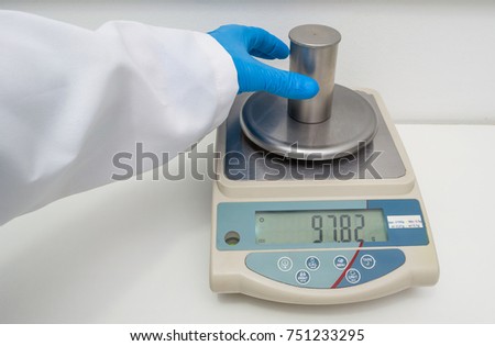 Great concept of research and development, hand measuring the density of a liquid with the pycnometer.
