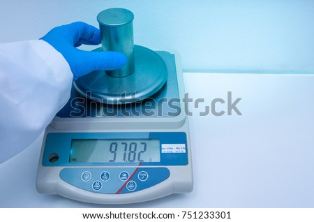 Great concept of research and development, hand measuring the density of a liquid with the pycnometer.