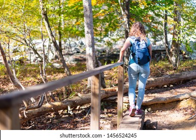 Great Falls In Maryland Colorful Autumn Foliage On Billy Goat Trail With Young Woman Hiker Crossing Creek Holding On Railing