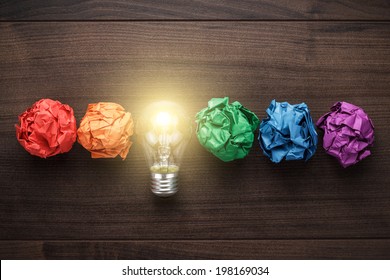 great idea concept with crumpled colorful paper and light bulb on wooden table - Shutterstock ID 198169034