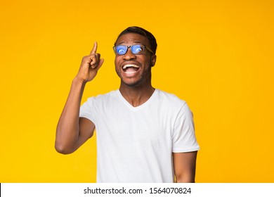 Great Idea. Excited Black Man Pointing Finger Up Having Eureka Moment Standing Over Yellow Background. Studio Shot