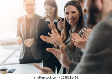 Great job! Successful business team is clapping their hands in modern workstation, celebrating the performance of new product